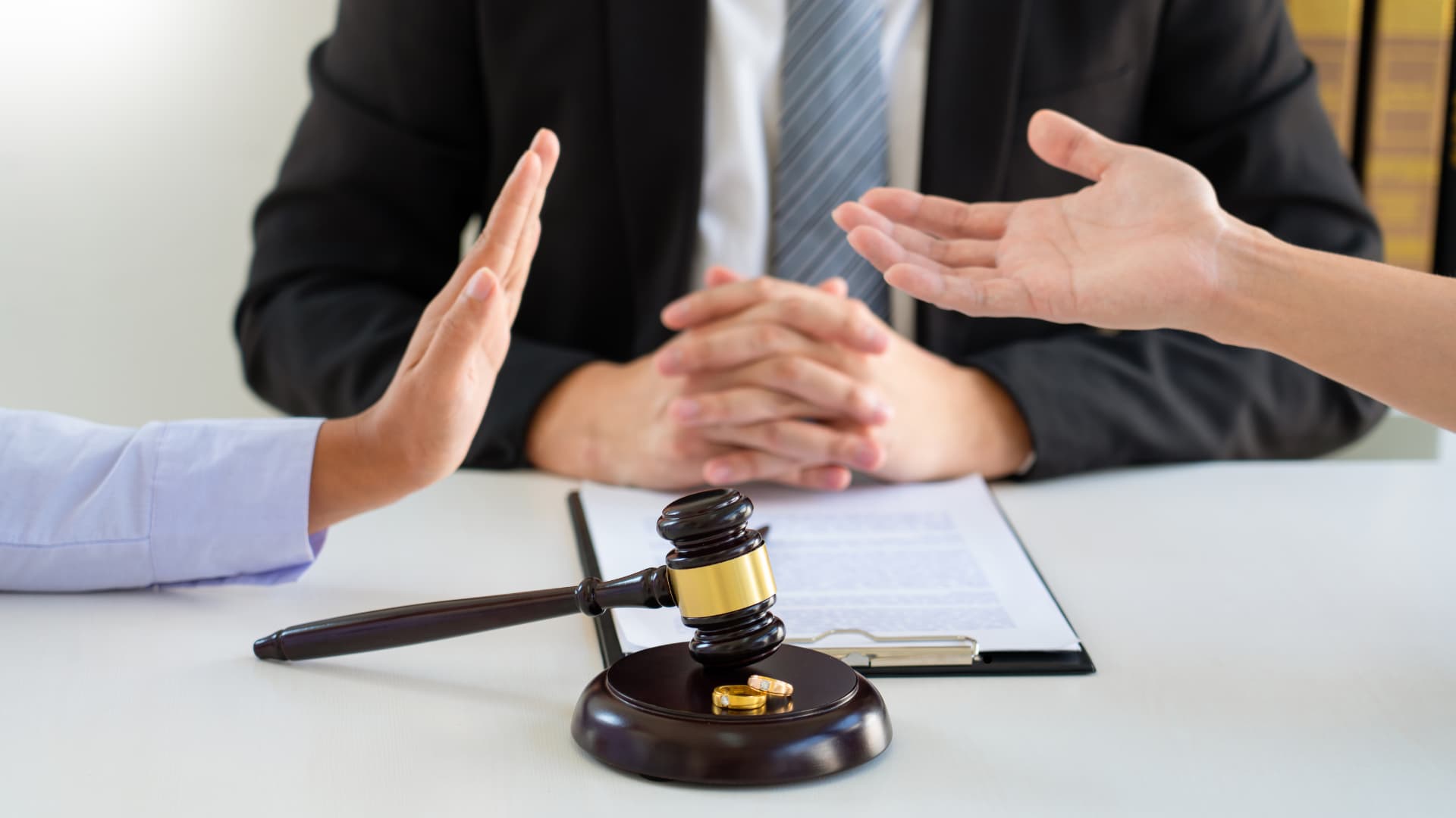 Wedding Rings with a gavel and two people debating and a third person mediating