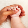 Parent holding hands with a baby